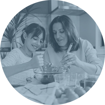 Smiling mother and daughter baking together in the kitchen