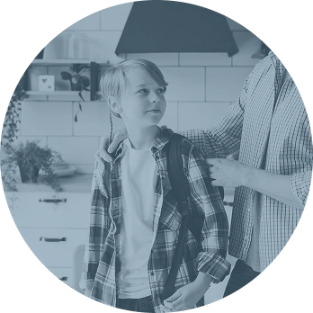 Parent helping young boy with backpack get ready for school