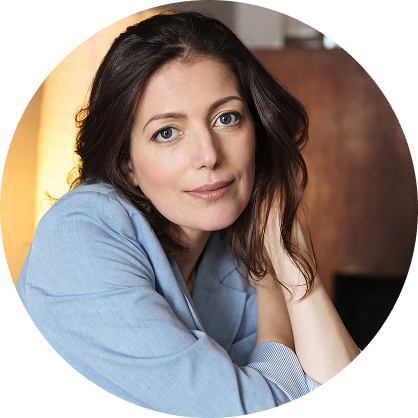 Woman in blue shirt resting her head on hand with calm expression